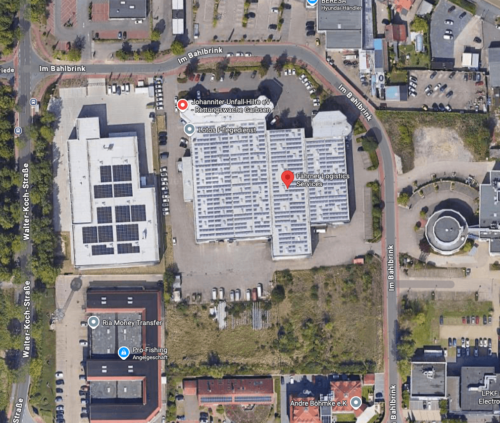 Satellitenansicht eines Gewerbegebiets in Garbsen mit großen Lagerhallen, Solaranlagen auf den Dächern und Parkplätzen.